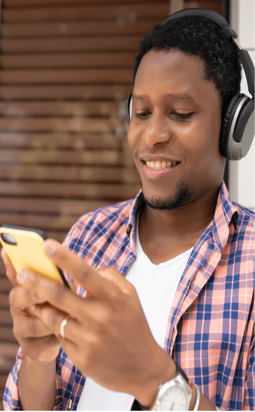 A smiling young man using his phone
