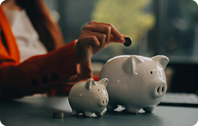 A coin being dropped into a piggy bank