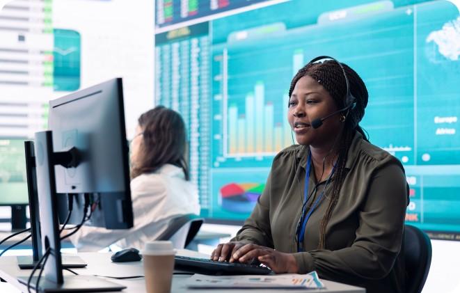A Kolomoni customer support agent wearing a headset at her desk