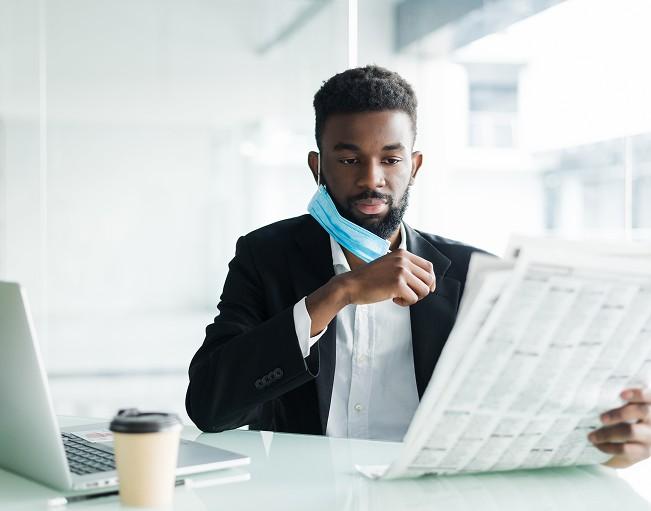 A Kolomoni loan officer reading the newspaper at his desk